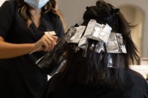 A colourist applying foils to dark hair at Tara Rose
