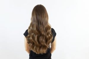 Long wavy hair with soft blonde tones, styled at Tara Rose
