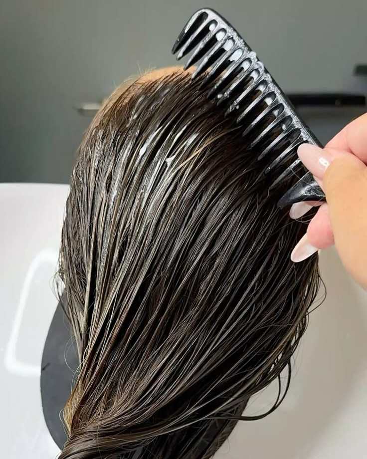 A treatment being combed through wet hair at Tara Rose